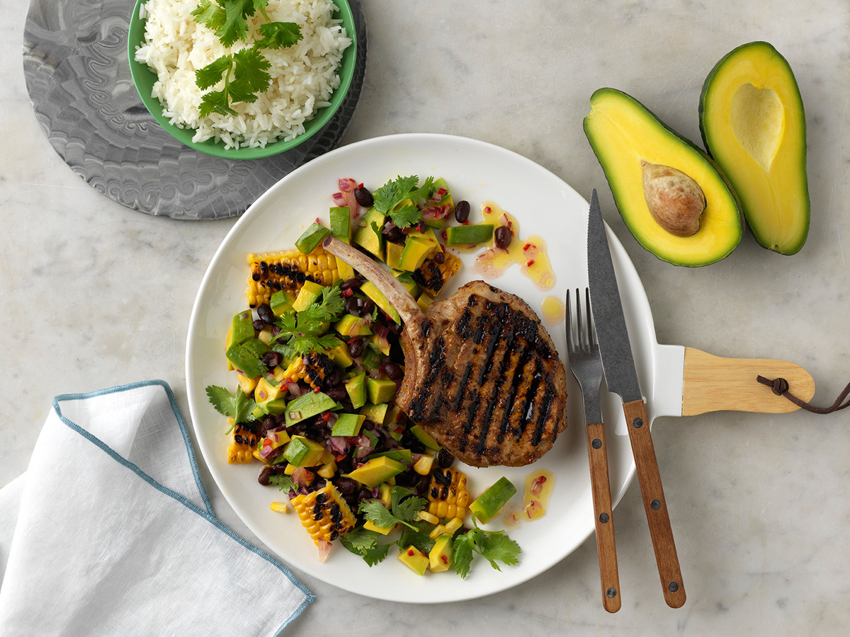 Grilled jerk pork cutlets with charred corn and avocado salsa.